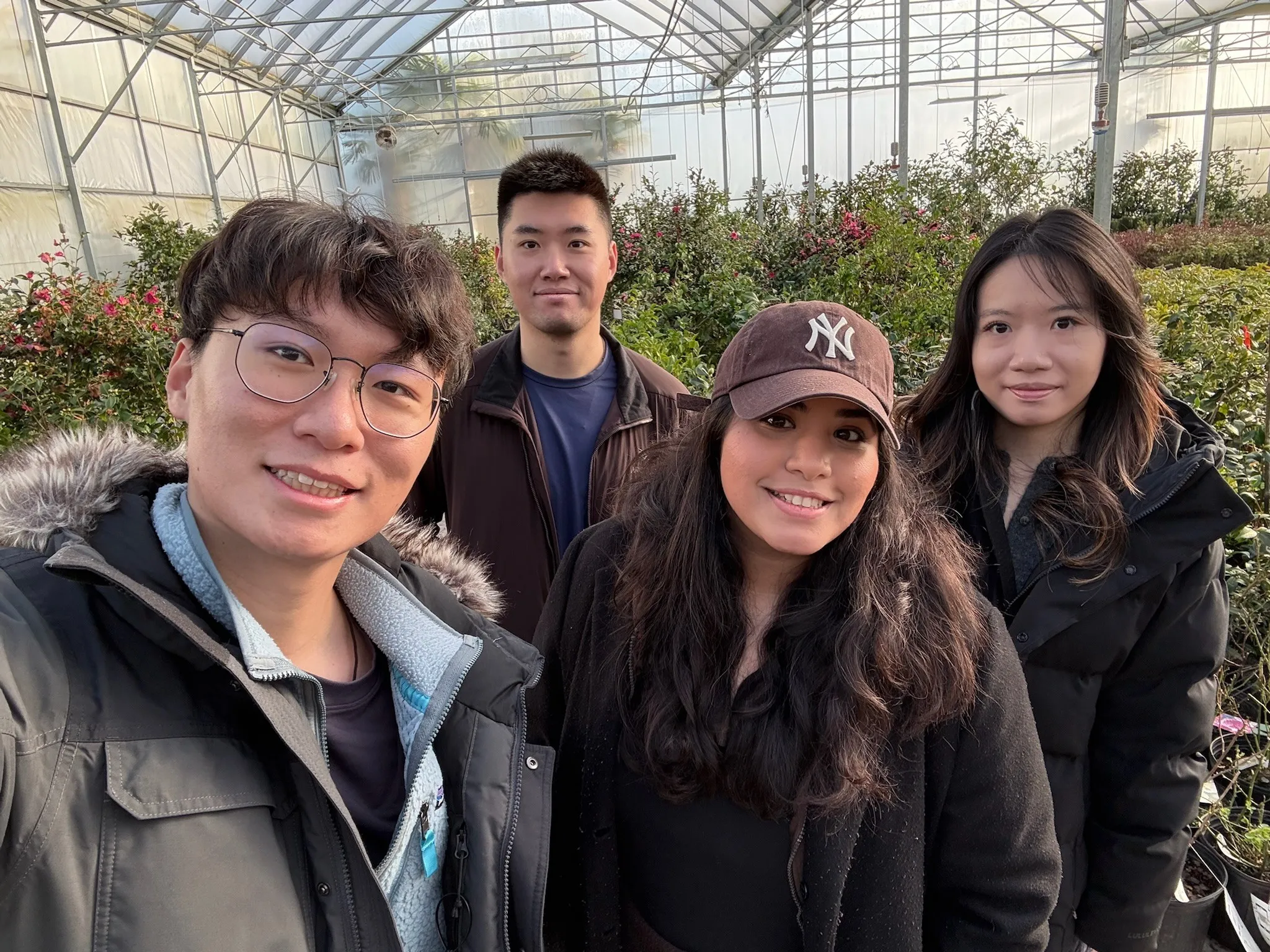 Selfie of four team members in a gardening centre greenhouse